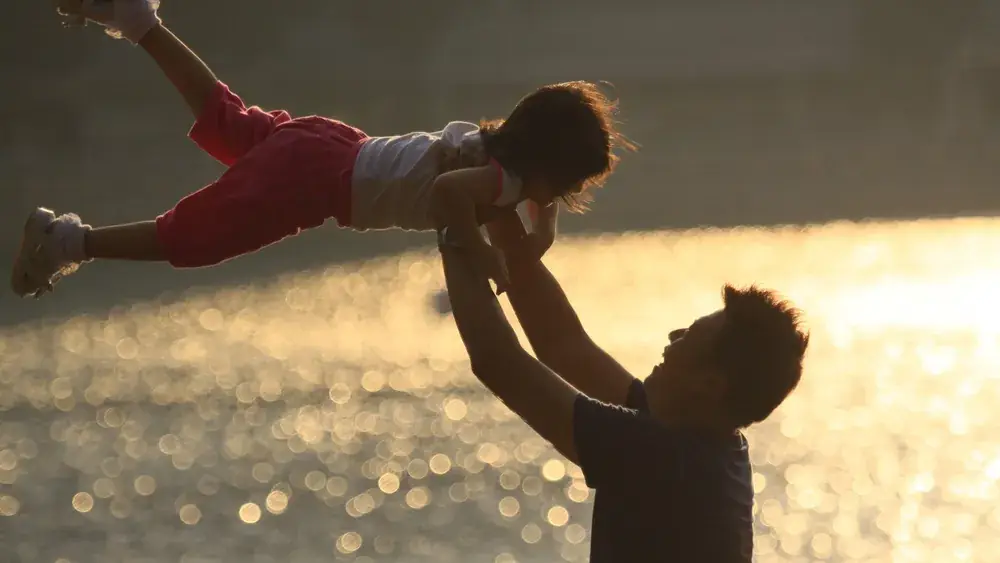 Un père et sa fille se balancent ensemble en plein air