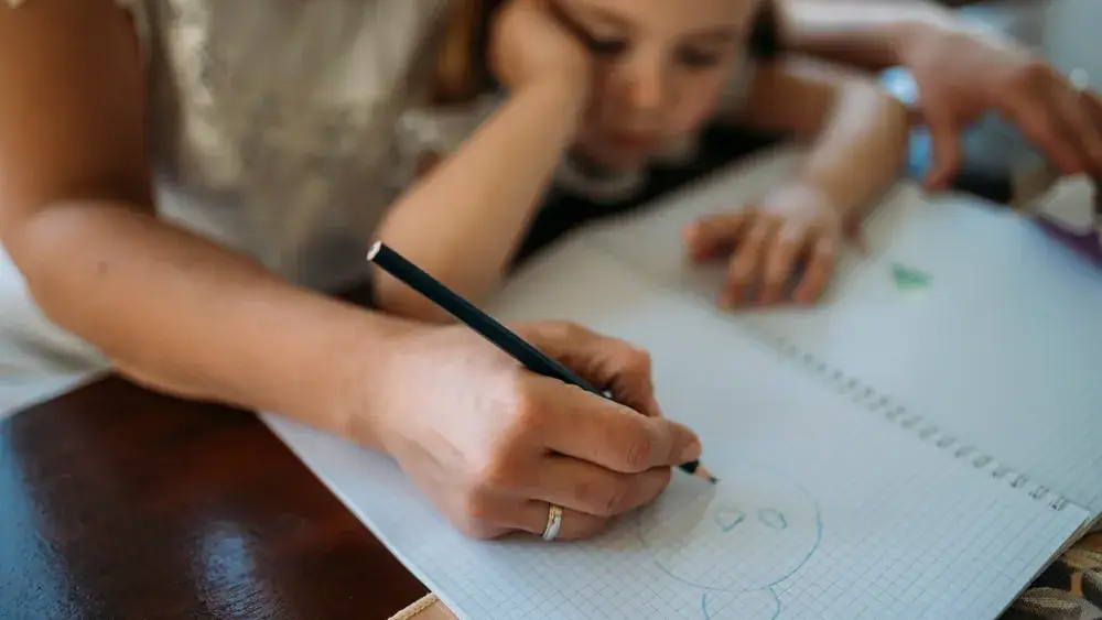 Adulte accompagnant un enfant dans une activité créative