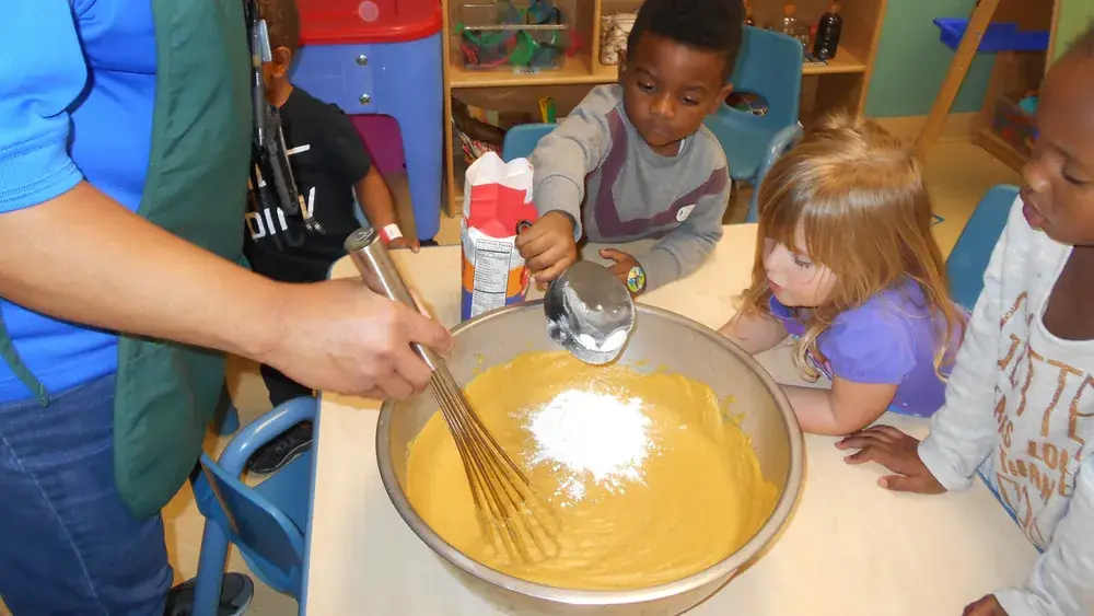 Enfants apprenant à cuisiner à tour de rôle dans une cuisine