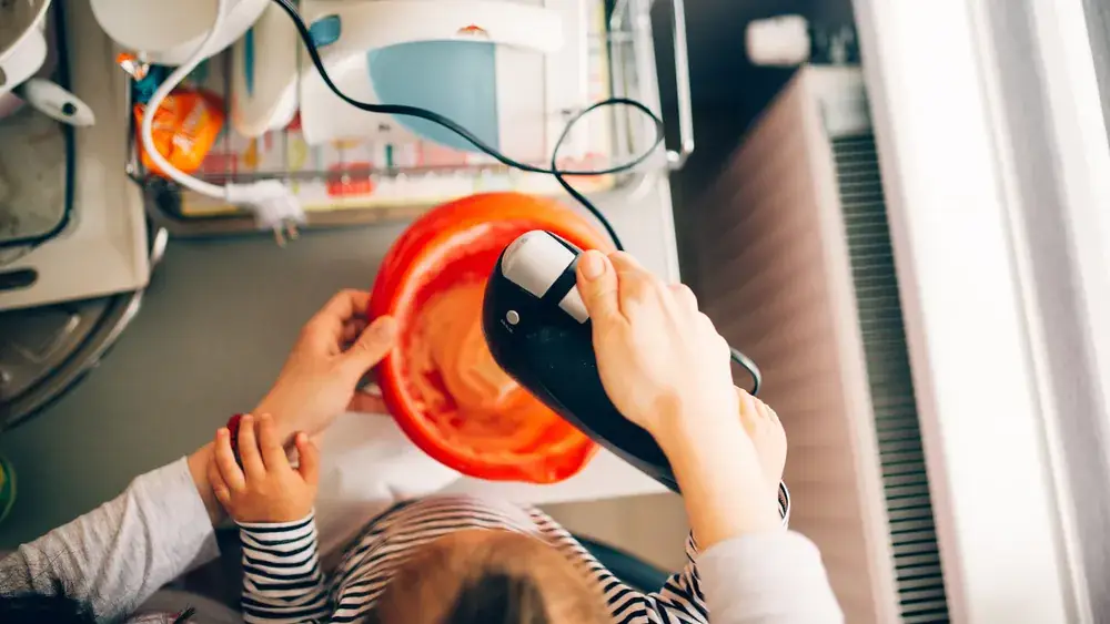 Enfant aidant à préparer une pâte à gâteau dans la cuisine