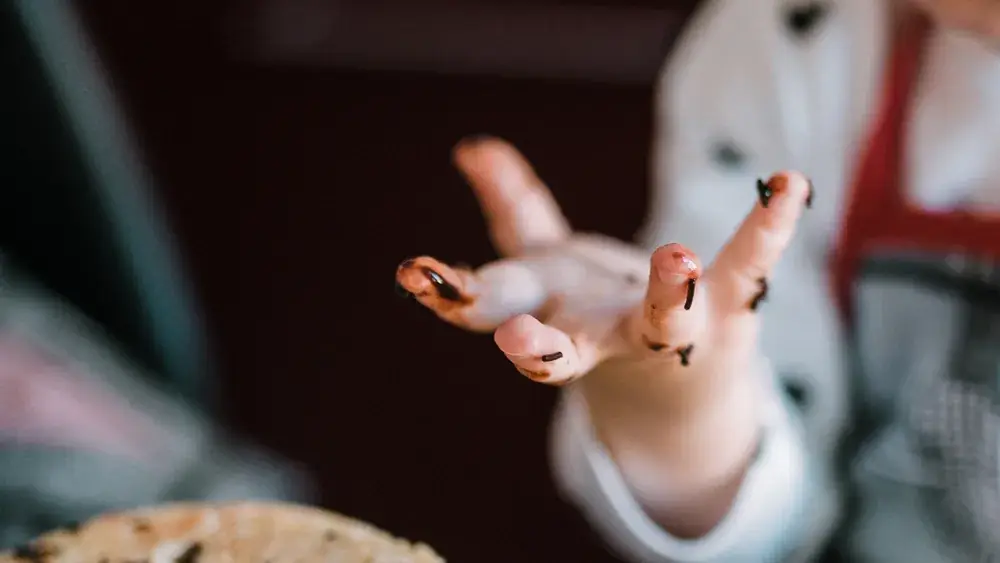 Enfant servant un gâteau fait maison dans une cuisine chaleureuse