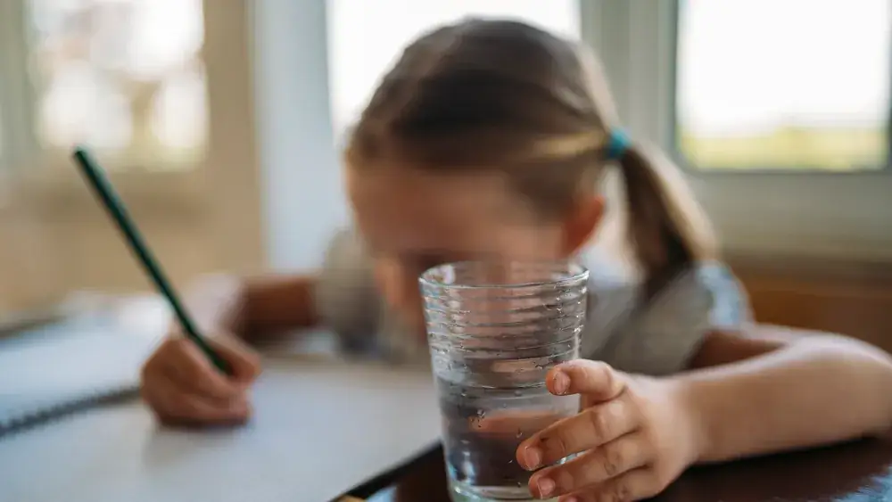 Enfant concentré sur ses devoirs à la table familiale